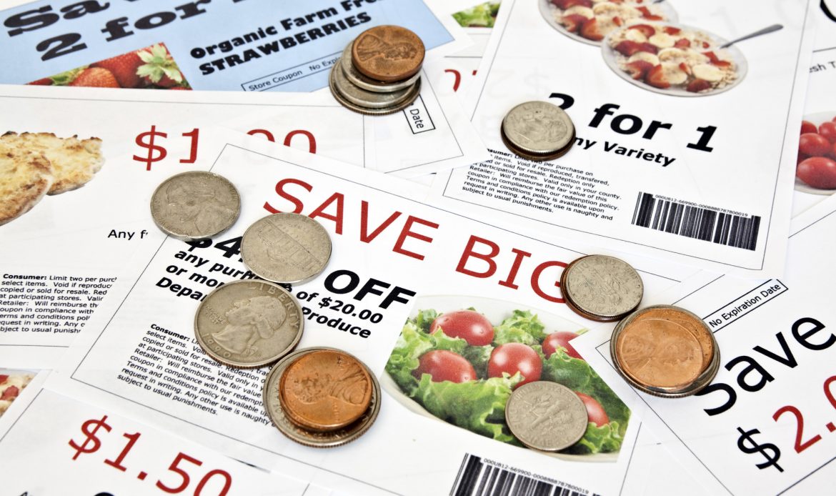A pile of coupons and coins on a table, showcasing extreme couponing.